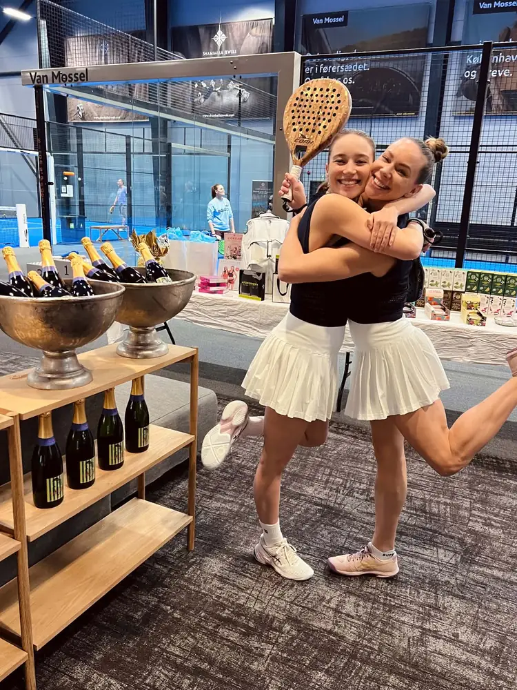 To spillere krammer foran præmiebordet ved en Ladies Padel Cup