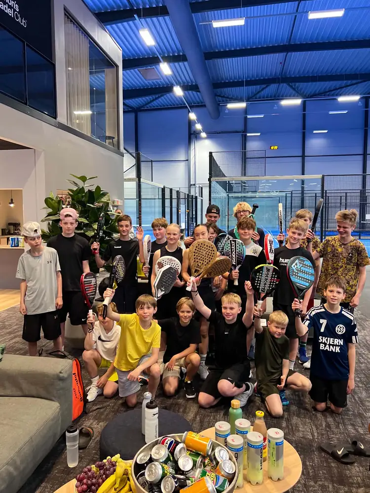 Alle deltagerne til en NextGen Cup samlet i loungen med bats i vejret