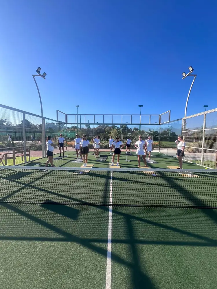 Morgenyoga på padelbanen under blå himmel